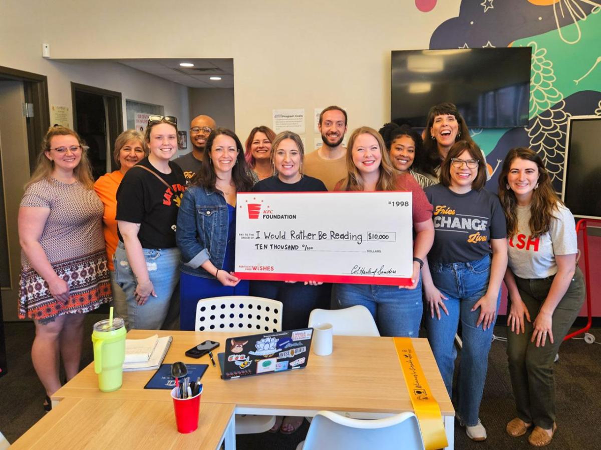 A group posed with a large check