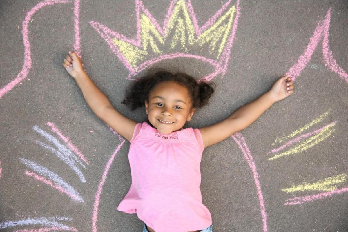 A little girl laying on a chalk outline