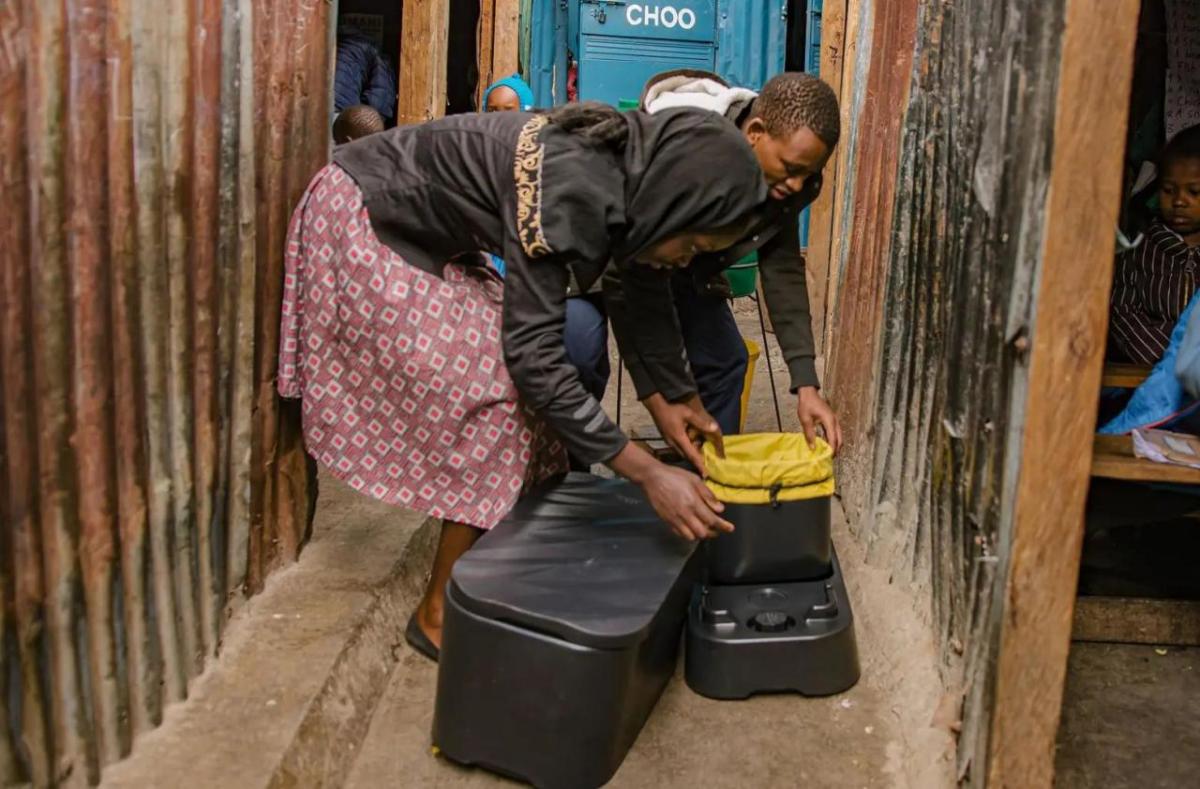 Two people assembling a loope toilet.