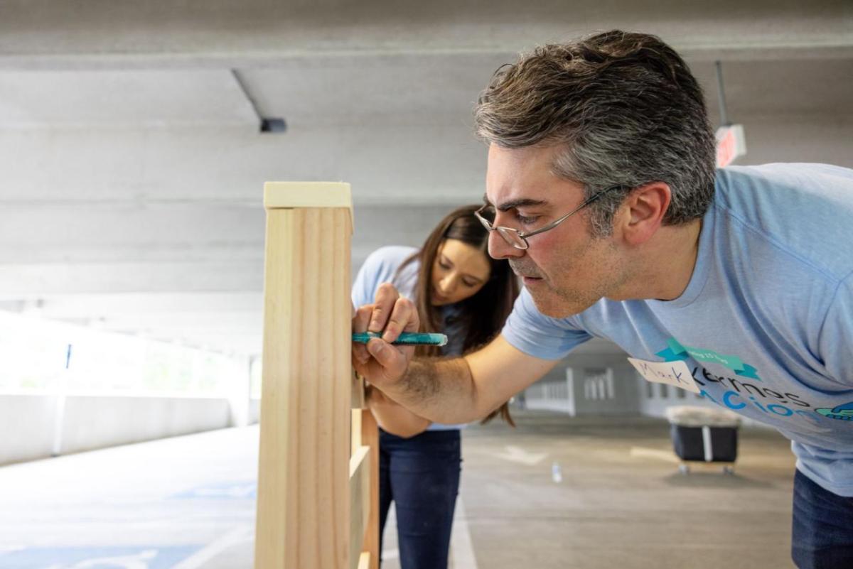 Volunteers mark the frame of a bed.