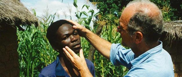 A person examines the eye of another