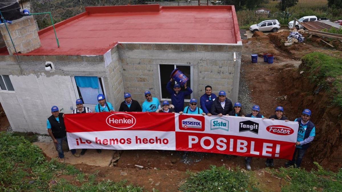 Overhead shot of people holding Henkel banner