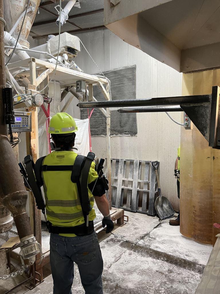 A person in protective gear in a manufacturing area.