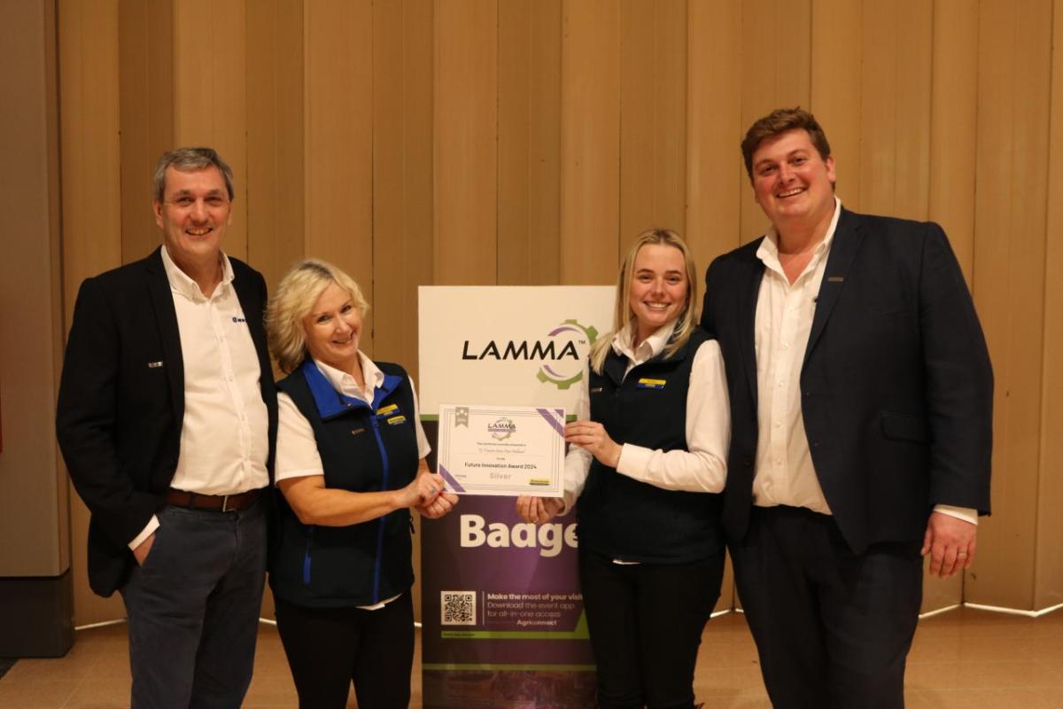 Four people standing together holding an award