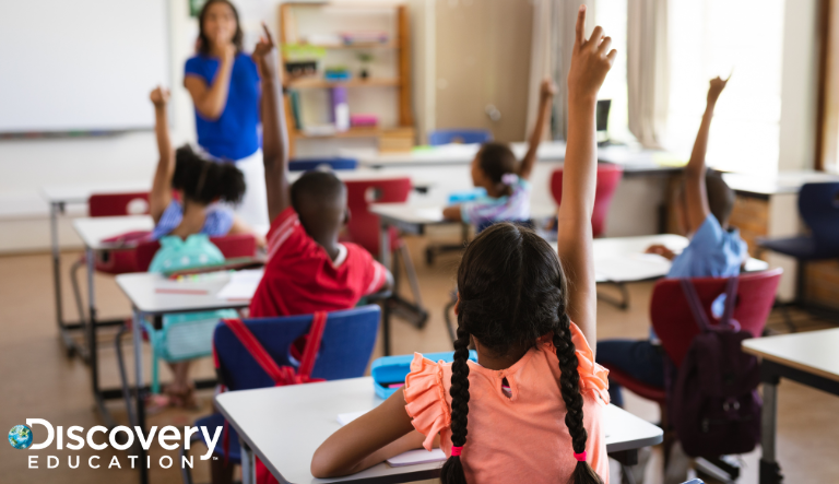 Children raising their hands in a classroom