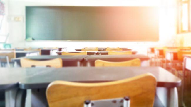 student desks and chairs facing a blackboard