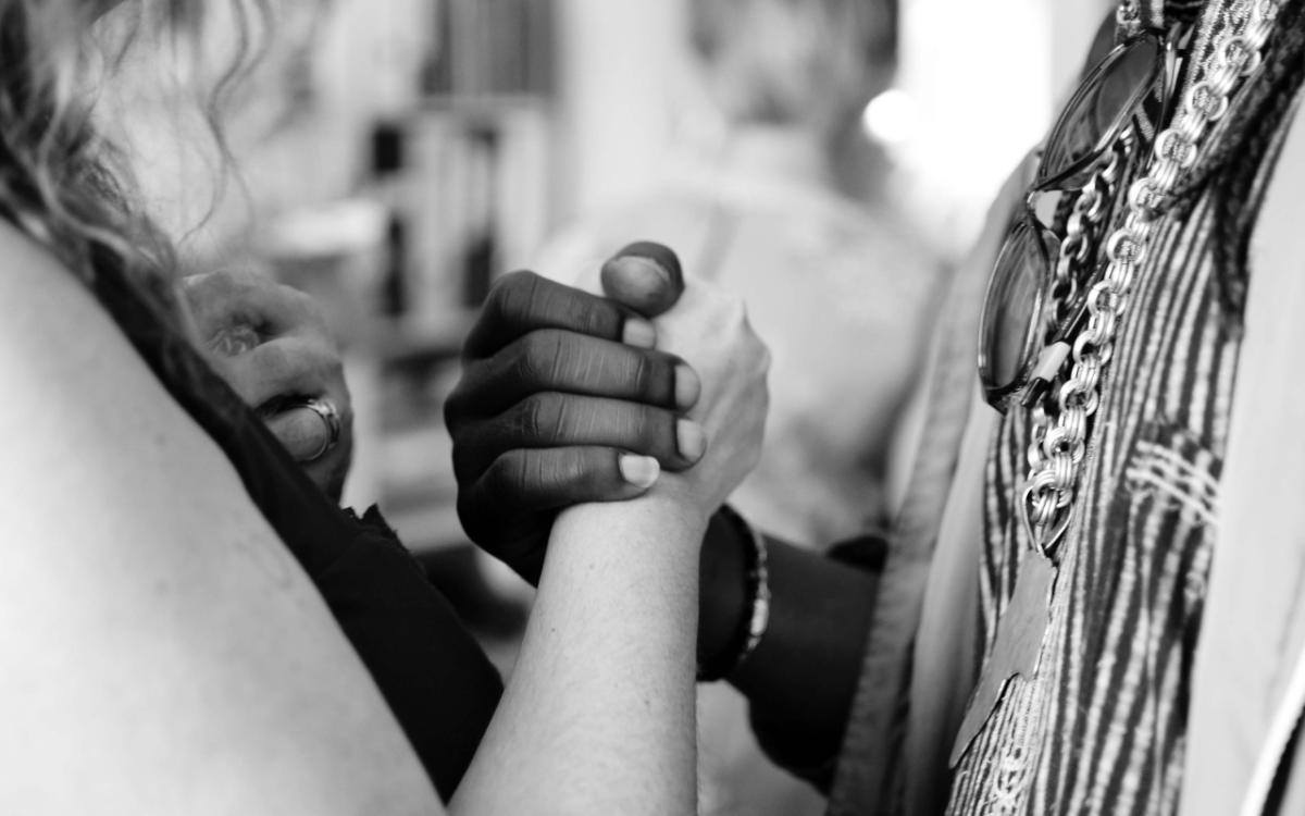 Two people clasping hands between them