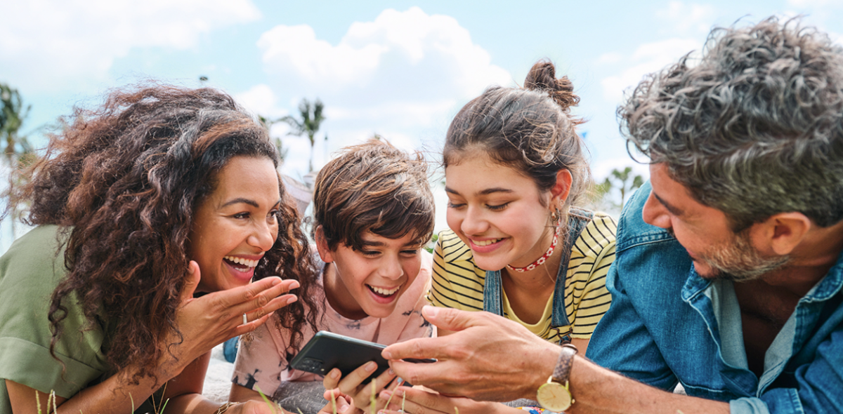 family looking at phone laughing