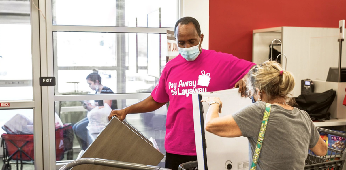 Man in Pay Away the Layaway shirt helping woman with boxes