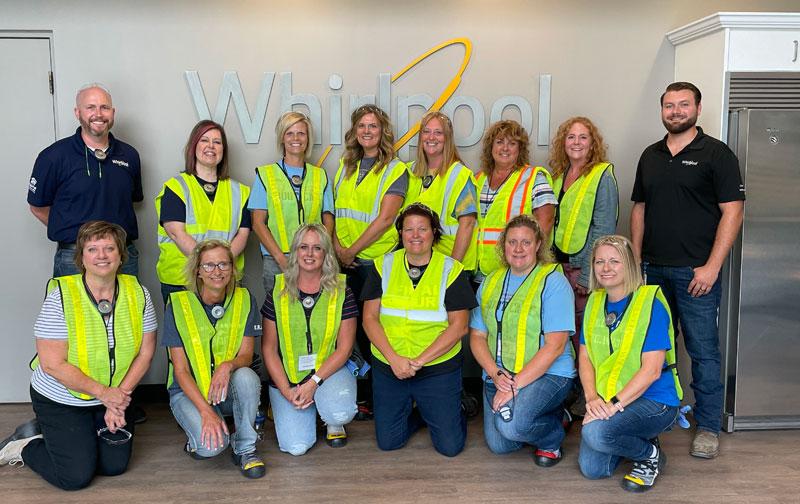 Group of teachers in yellow vests in front of Whirlpool Sign