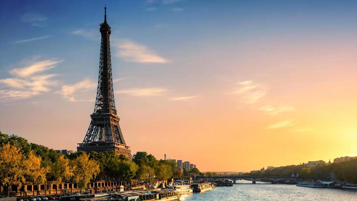 Eiffel Tower with a setting sun to the side.