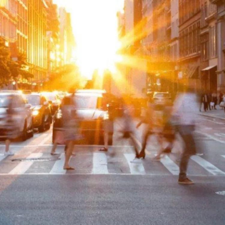 Blurred people crossing a busy street.