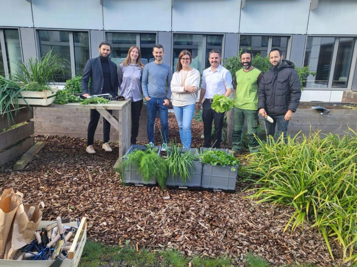 A group posed outside, behind planters