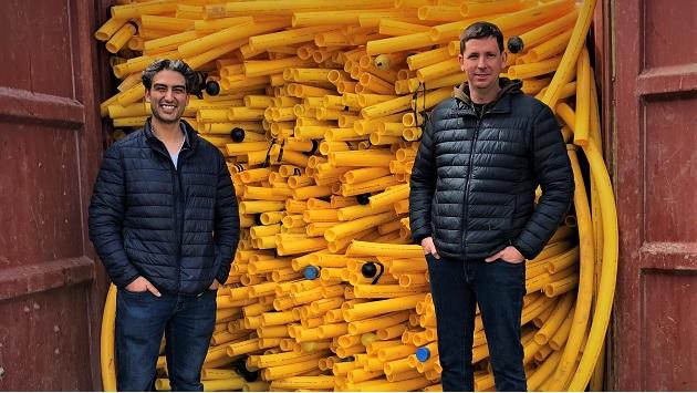 Canellos, left, and Waller with one of four bins collected in one week—totaling 25,000 pounds of pipe.