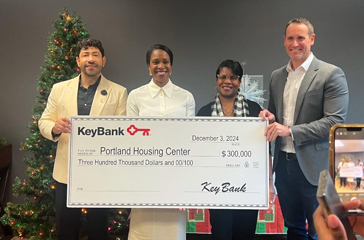 Four people holding an oversized check from KeyBank