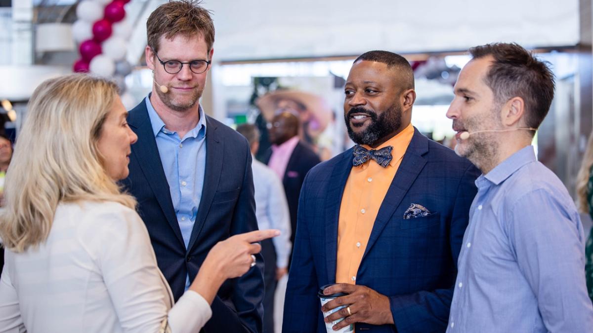 Four people standing in a group talking