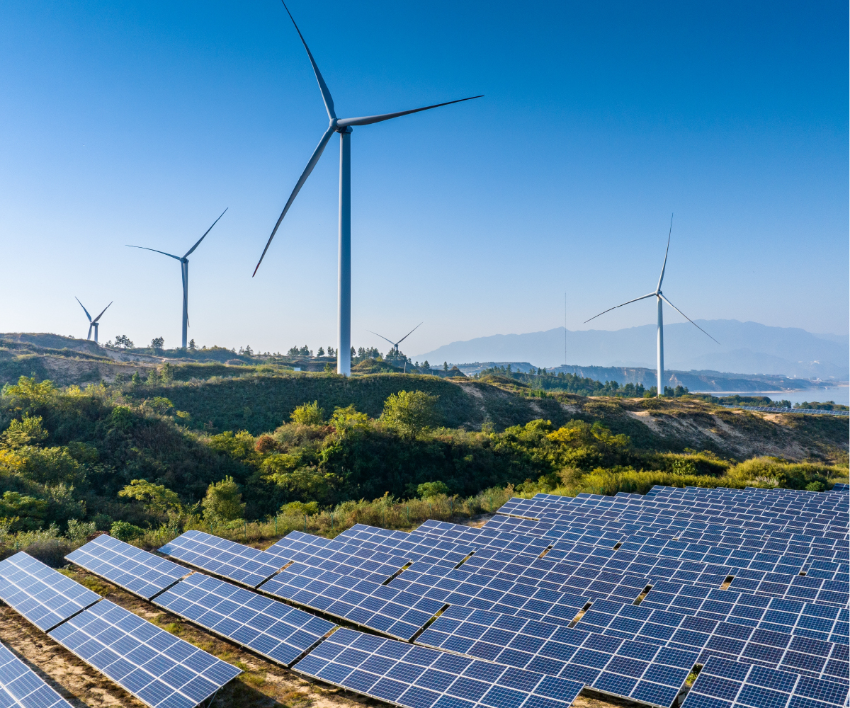 Wind turbines on a landscape next to solar panels