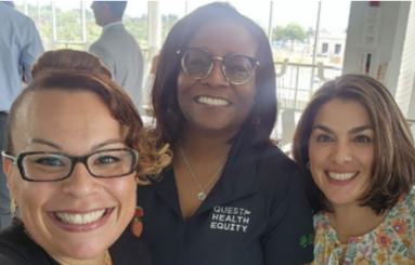 Three smiling people taking a selfie.