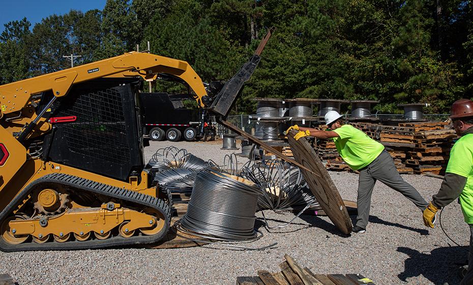 Workers dismantling a wooden spool