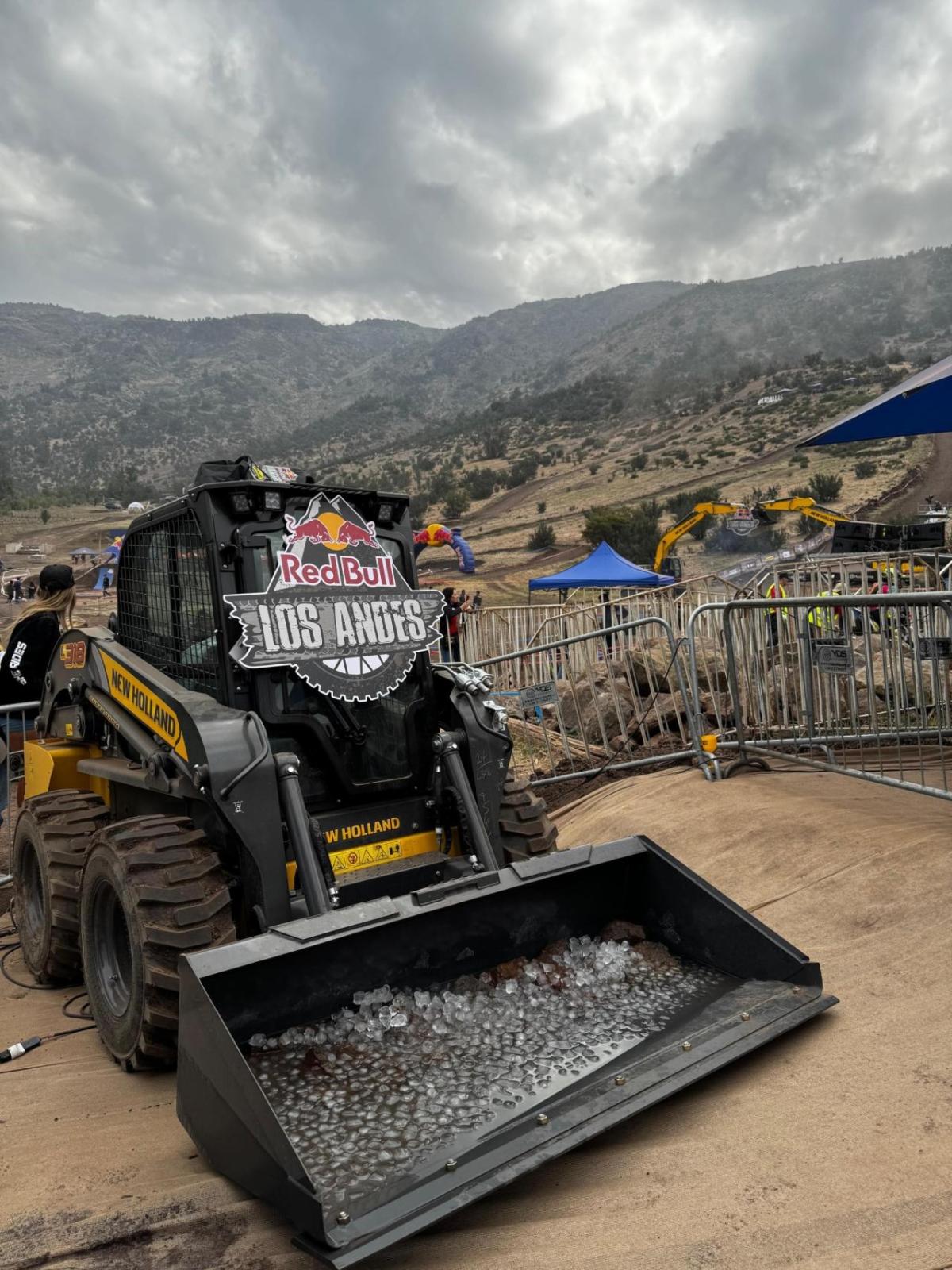 A small construction vehicle on dirt terrain. "Red Bull Los Andes" sign on the front.