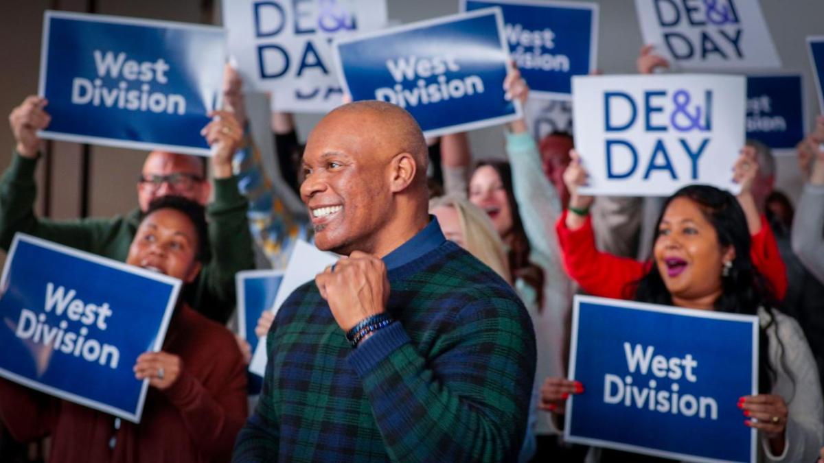 Rich Jennings in front of people holding DE&I signs