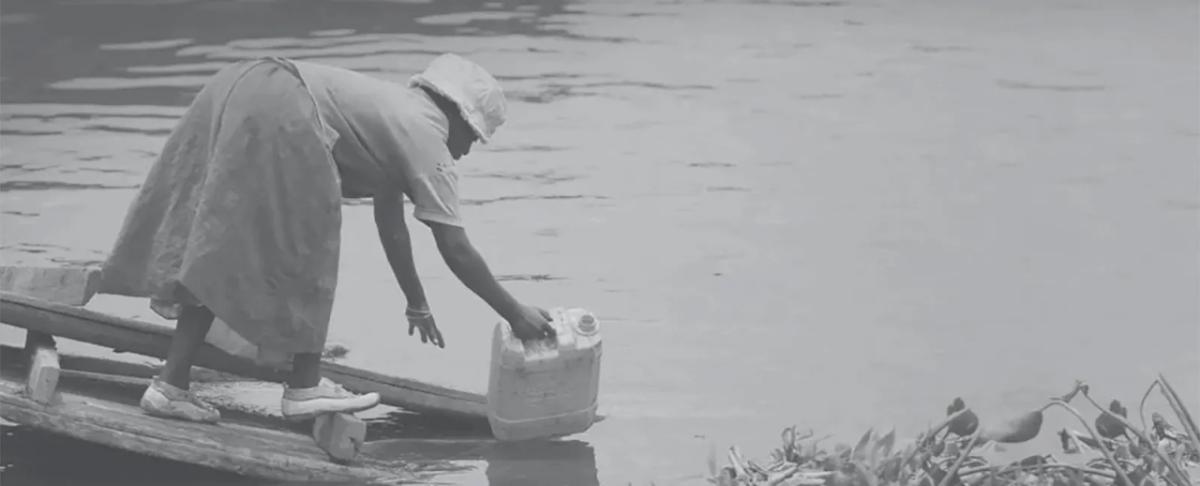 a person collects water with a jug