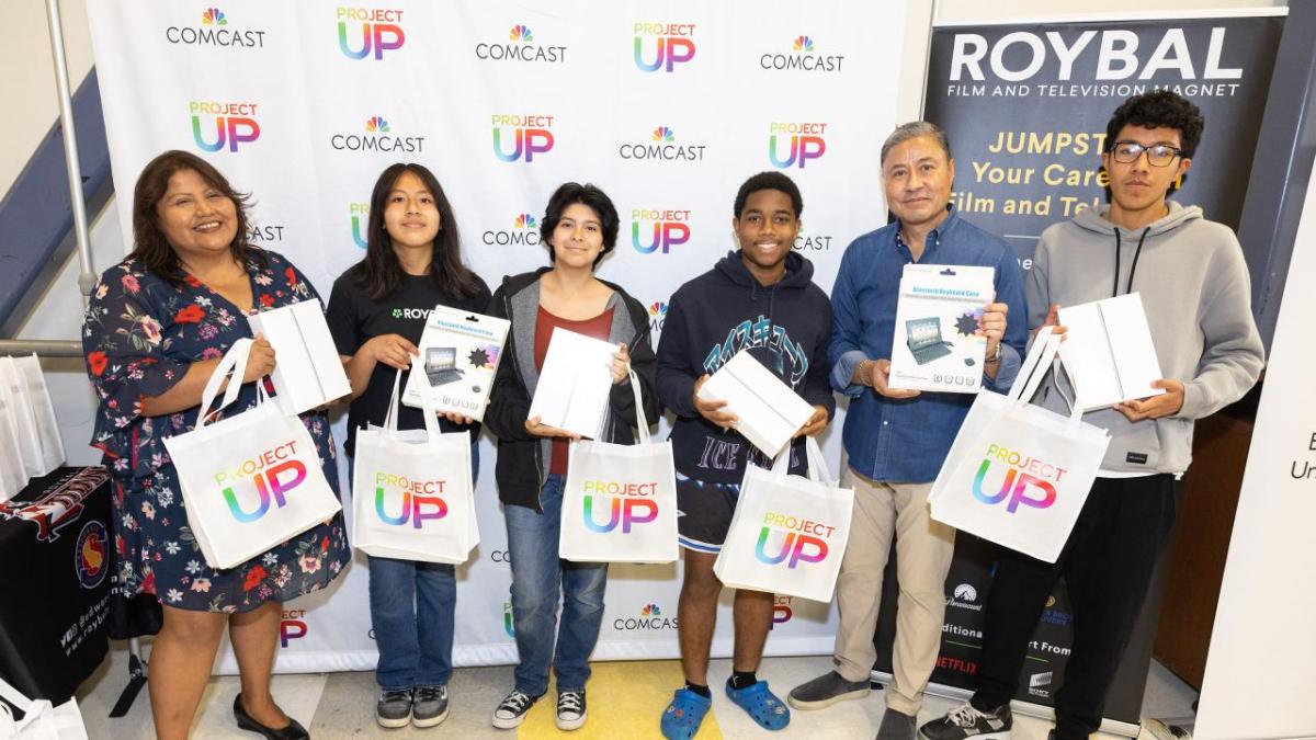 Six people posed with matching bags.