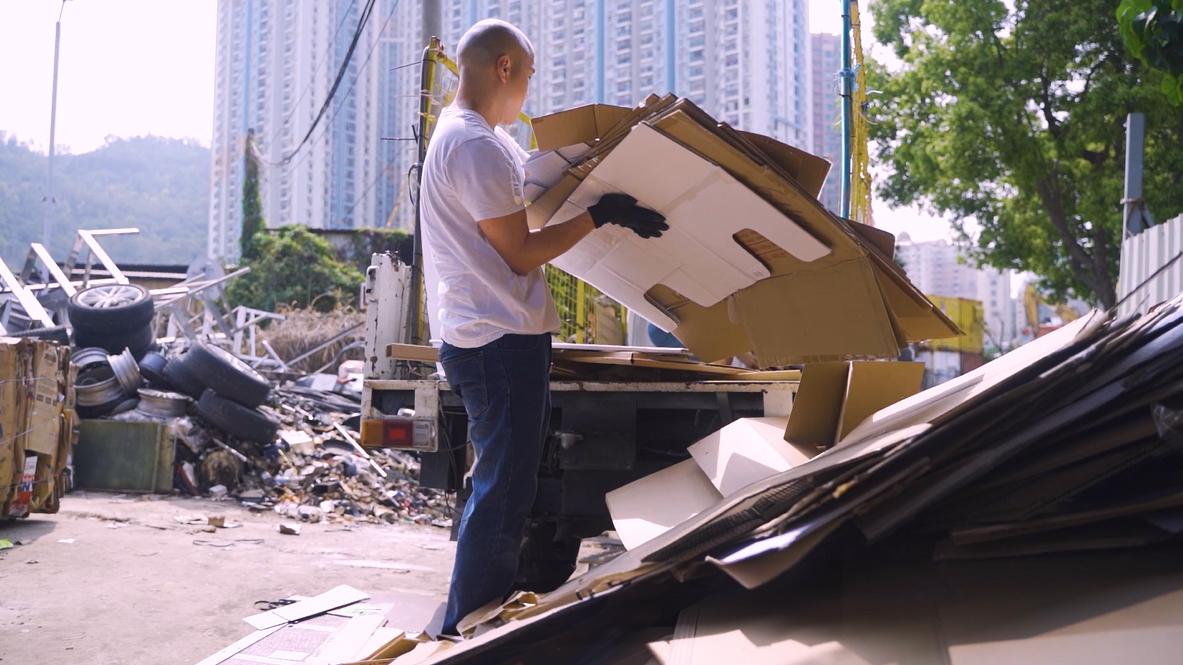 A person collecting cardboard outside.