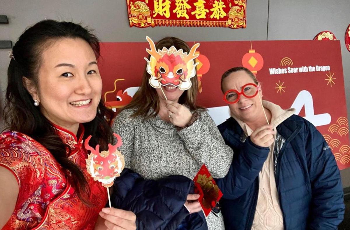 Three people holding up masks