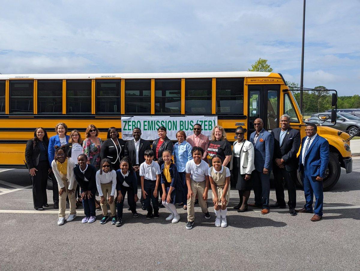 Grantee staff with school officials beside an electric school bus in Clayton County, Georgia