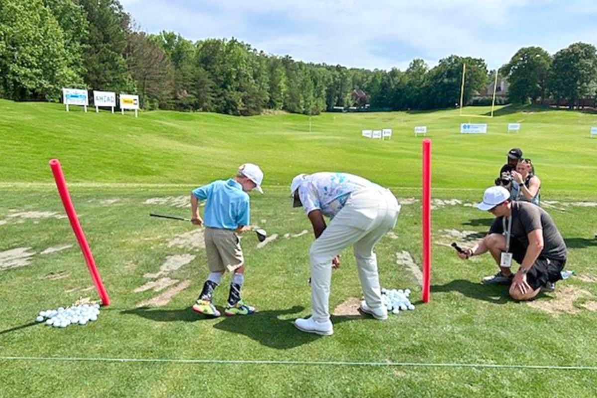 A child preparing to hit golf balls