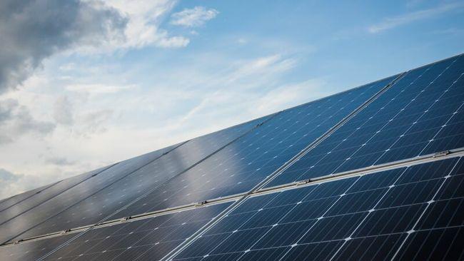 solar panels with a blue sky and clouds in the background