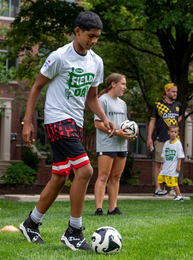 Children playing with soccer balls in a park setting