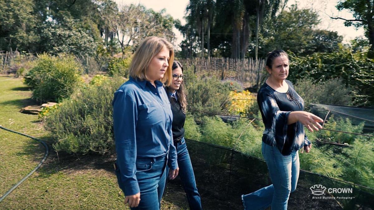 Three people walking through a garden