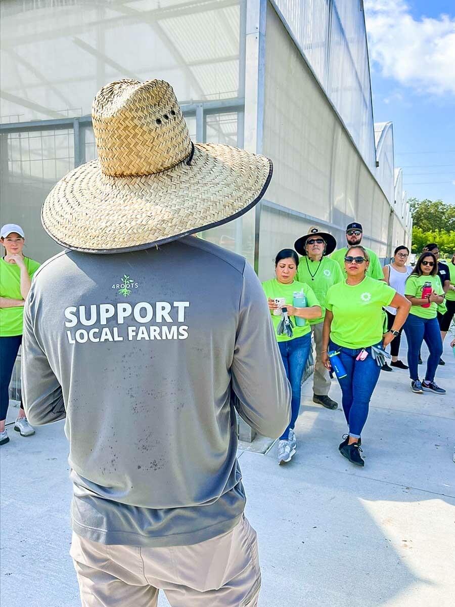 A person wearing a long sleeved t-shirt that reads "support local farms"