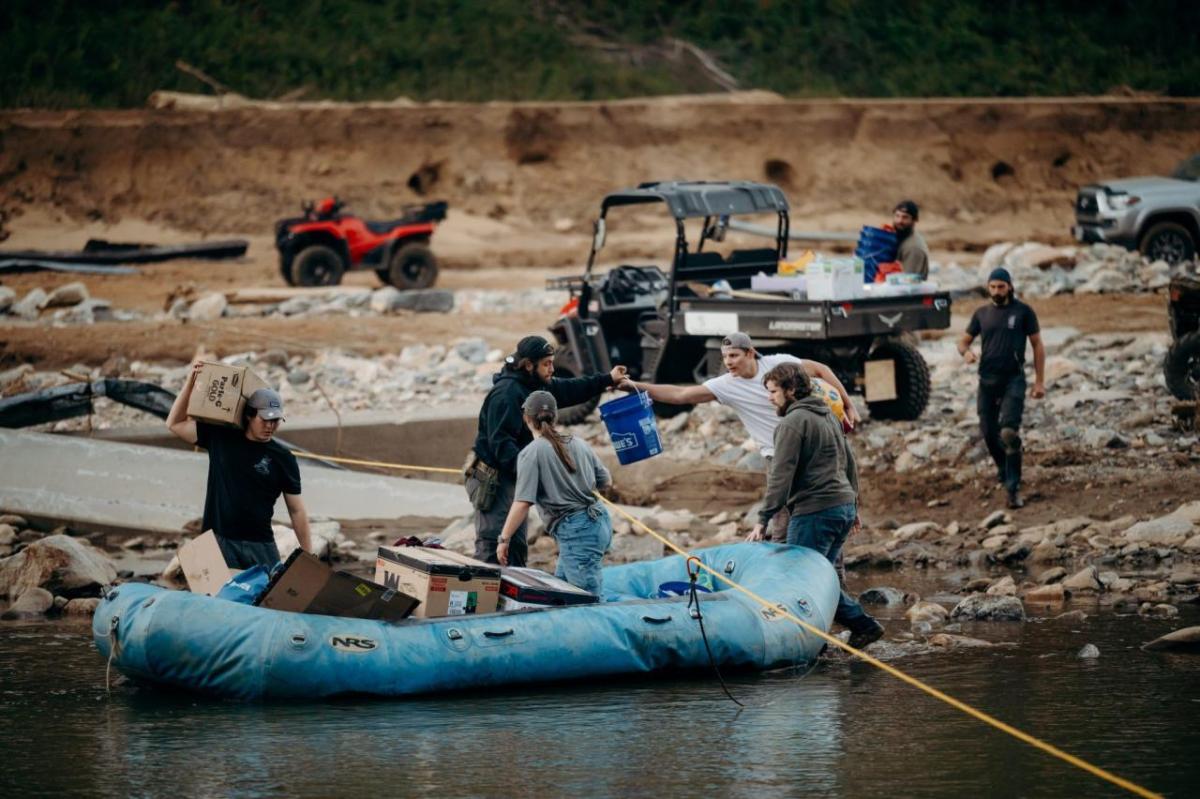 People loading supplies into an inflatable boat