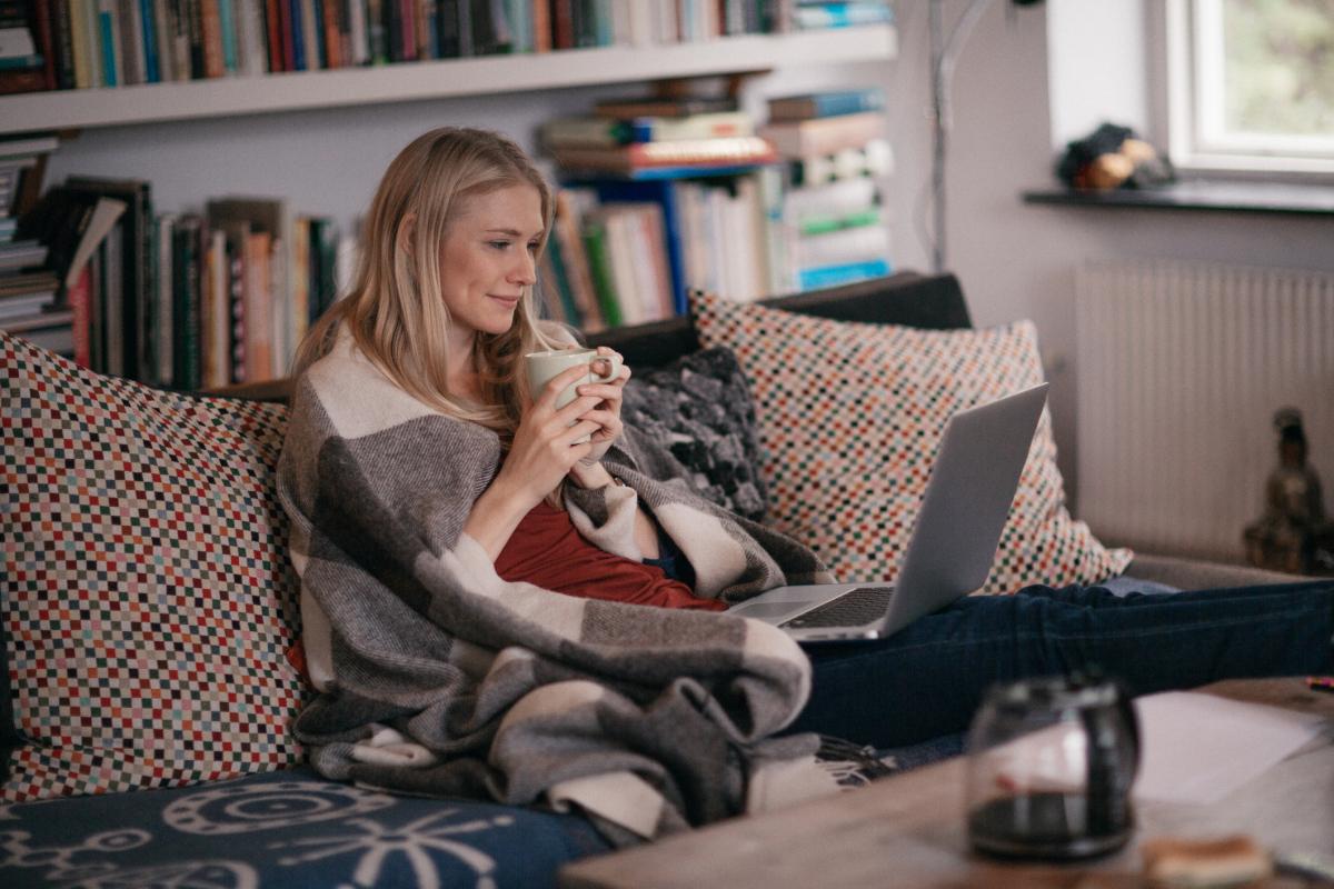 person sitting on a couch watching a laptop