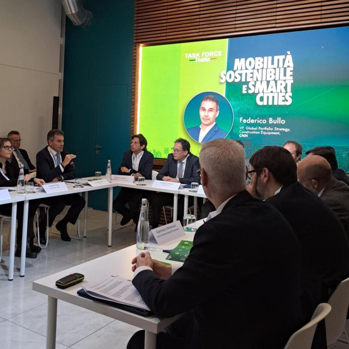 Group at roundtable event with presentation screen behind them