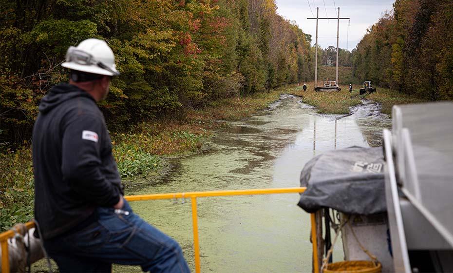 Duke employee on a boat in the swamp