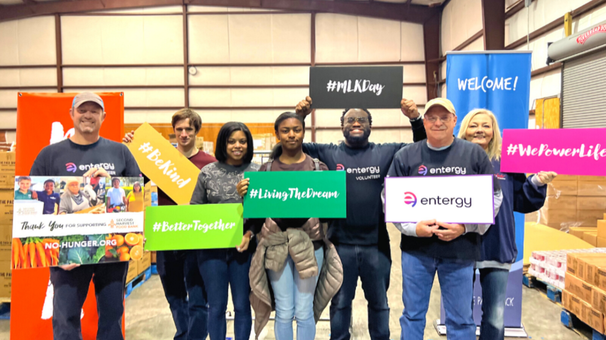 A group of people posed, each holding a sign.