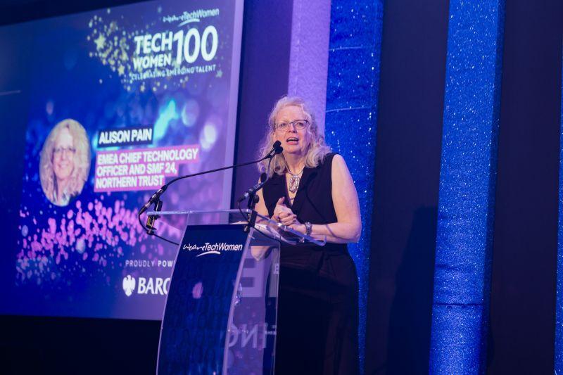 Alison Pain speaking at a purple dais