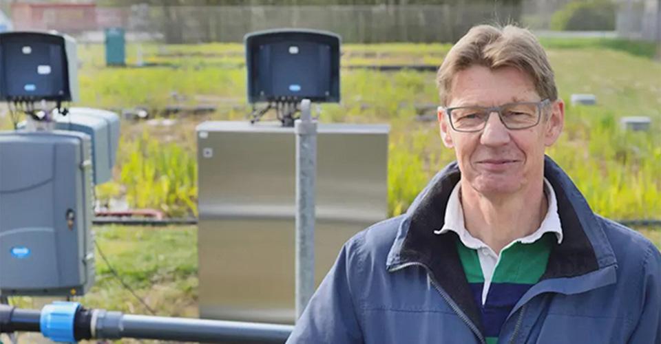 person standing in front of a field with piping and equipment