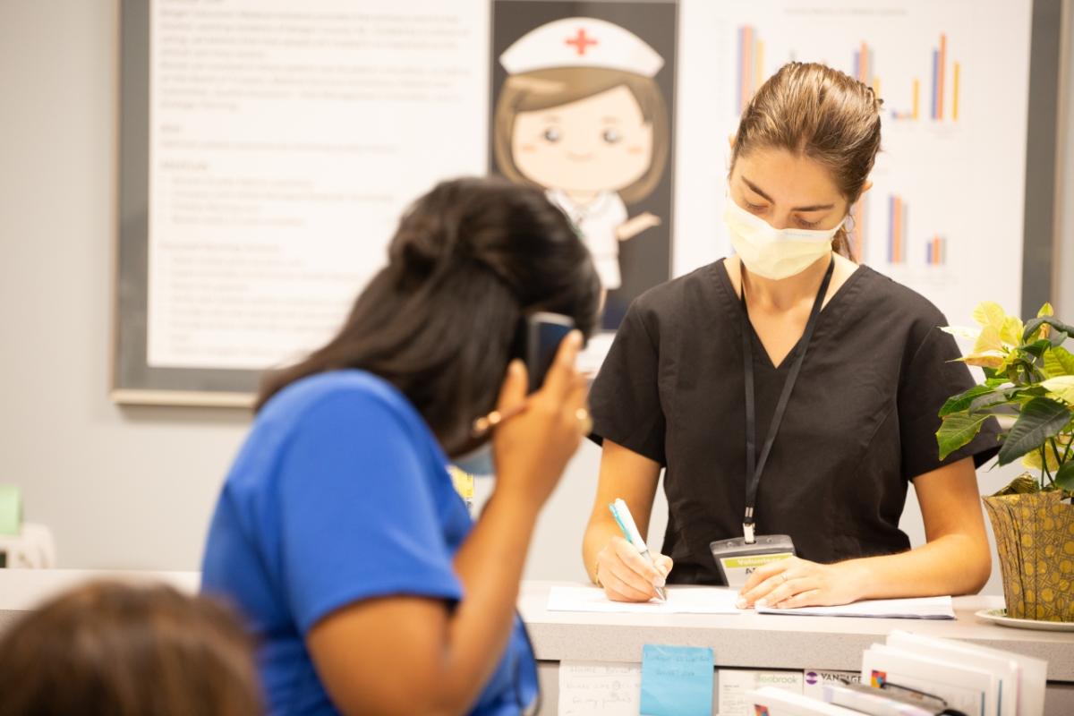 Two health care workers at reception desk