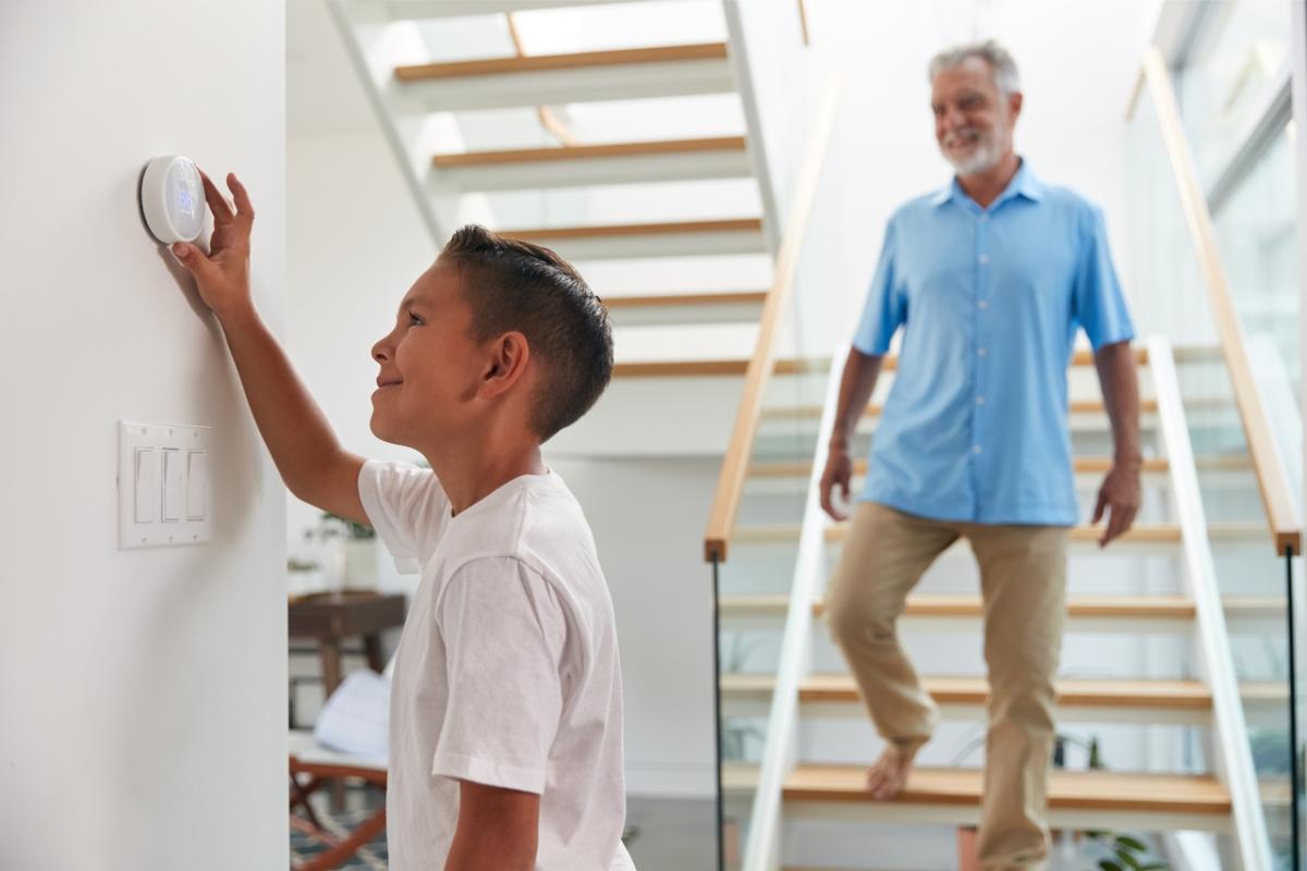 teen adjusting the thermostat