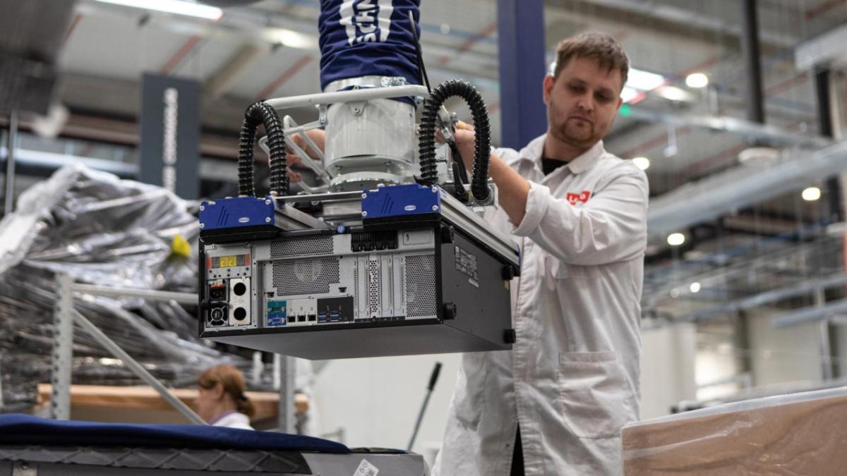 A person using machinery to lift a computer tower.