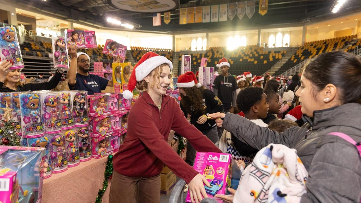 A volunteer handing out toys to others