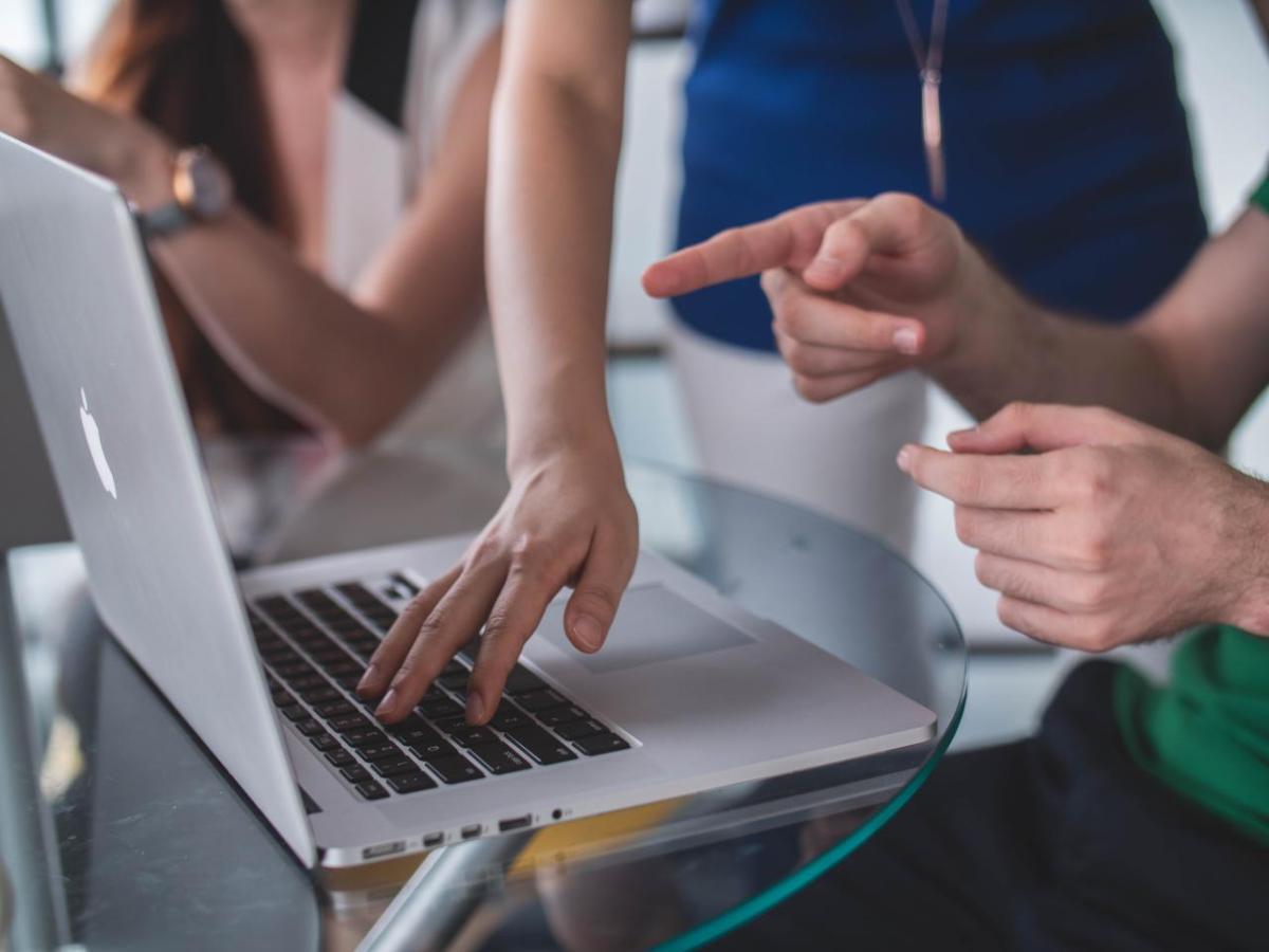 people's hands in front of laptop