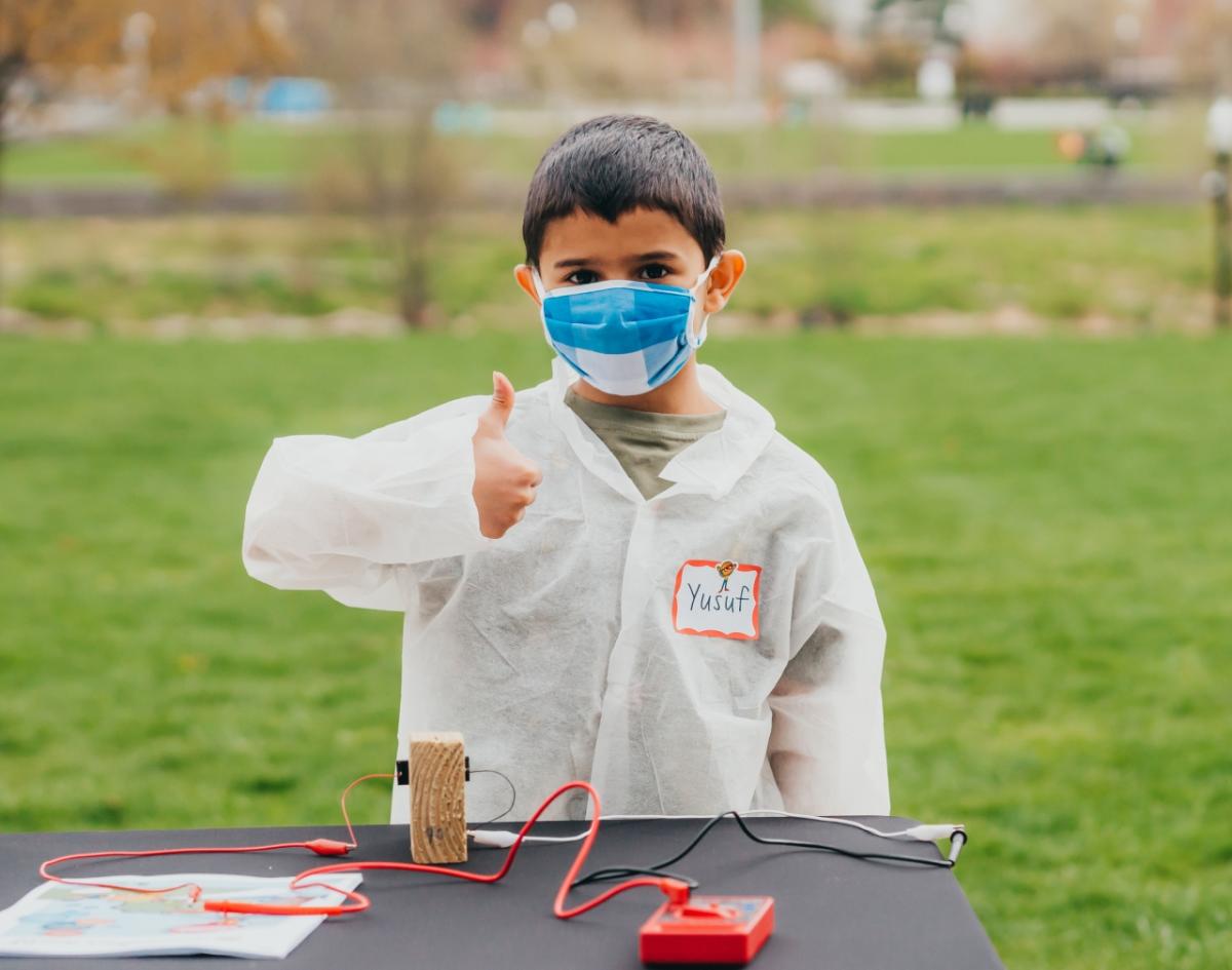 Boy giving thumbs up in front of science project