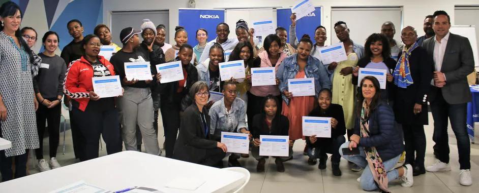 a group of people in a room, many holding certificates