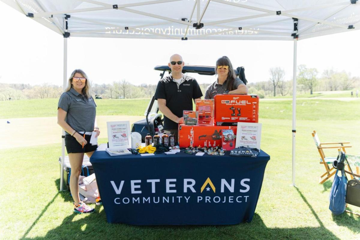 People behind a booth "Veterans Community Project"